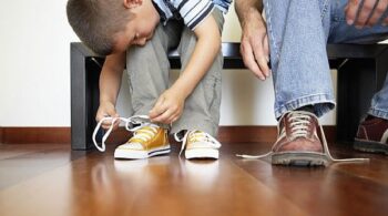 Young boy tying his shoes