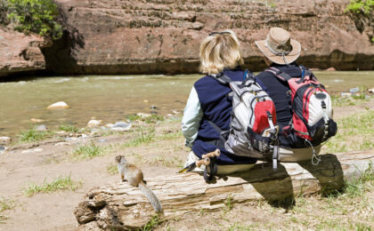 A couple who could sfford to retire enjoying a hike along the river.