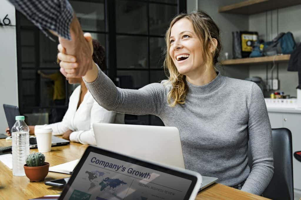 woman smiling and shaking hands