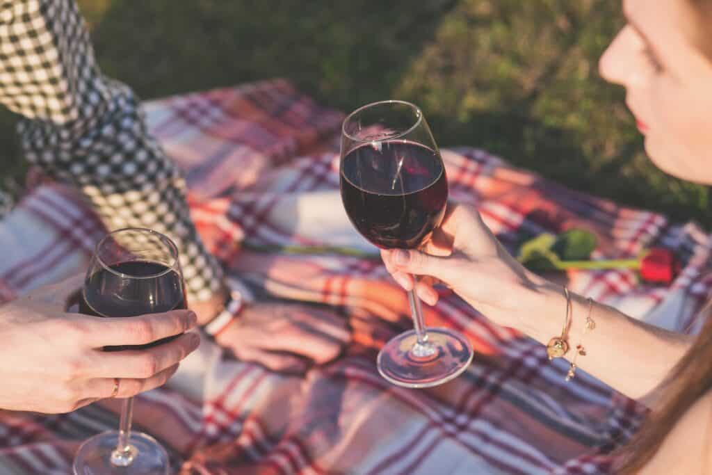 man and woman sharing wine on a blanket