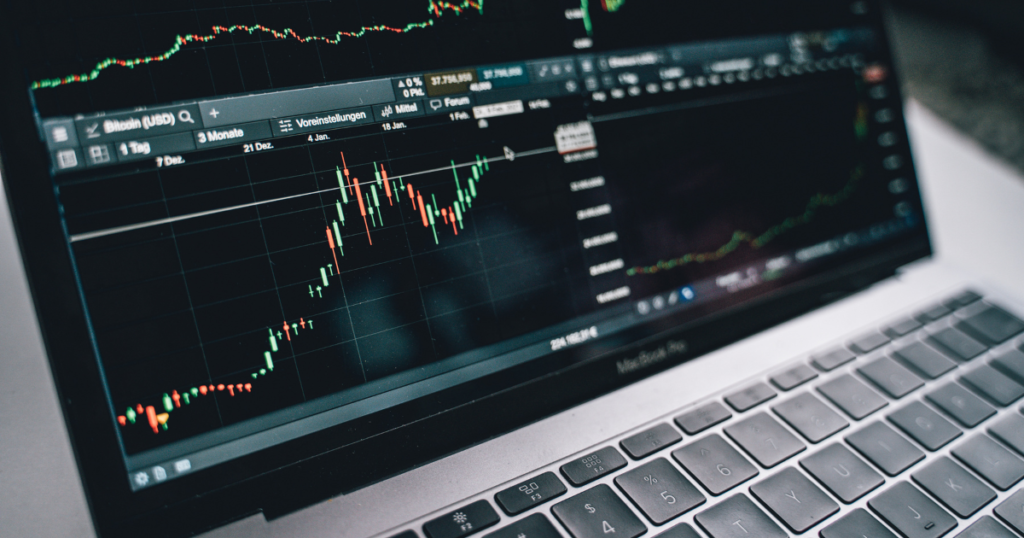 Laptop with stock chart depicting using the extra cash flow to invest and retire with MLM over 50