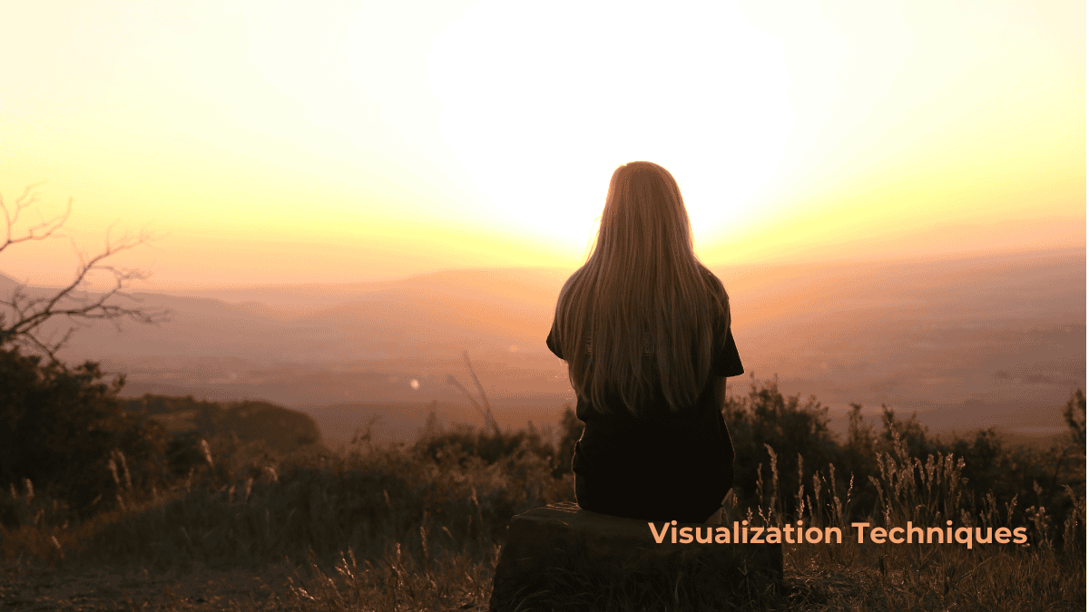 person sitting quietly on a rock, watching the sunset and practicing visualization techniques